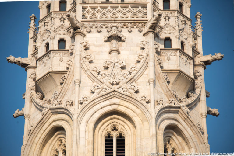 Close architectural detail of Matthias Church tower with pointed arches, tracery, pinnacles, balconies, and projecting carved figures.