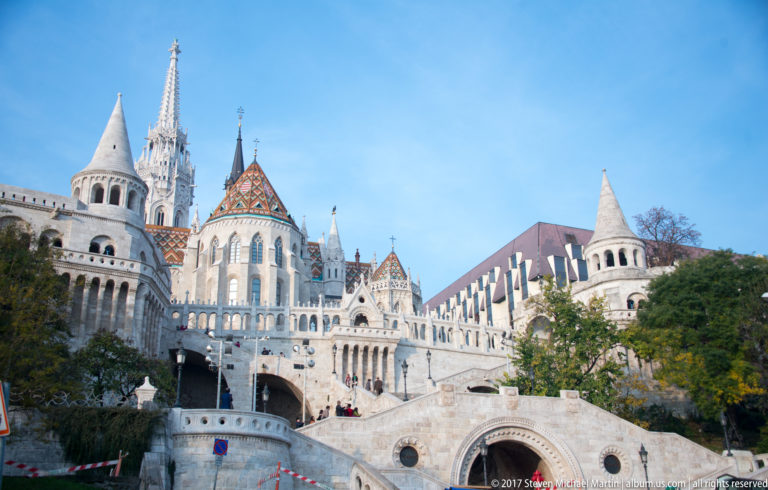 Stone stairs and conical turrets of Fisherman’s Bastion lead toward the tiled apse and spire of Matthias Church.