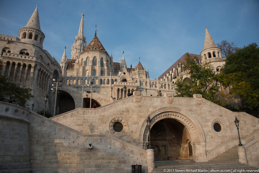 Monumental stone stairway and deep round-arched passage at Fisherman’s Bastion, with Matthias Church rising behind.