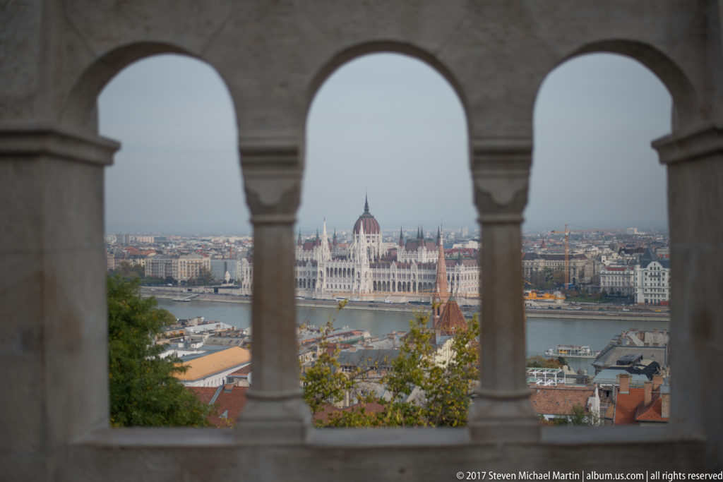 Hungarian Parliament Building across the Danube seen through two stone arches at Fisherman’s Bastion.