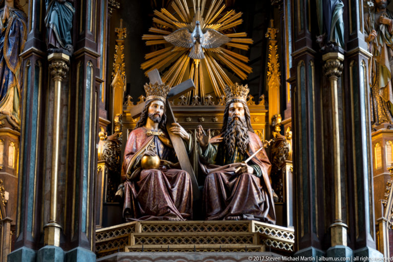 Holy Trinity sculpture in a Kraków church, with Christ and God the Father seated beneath a radiant dove of the Holy Spirit.