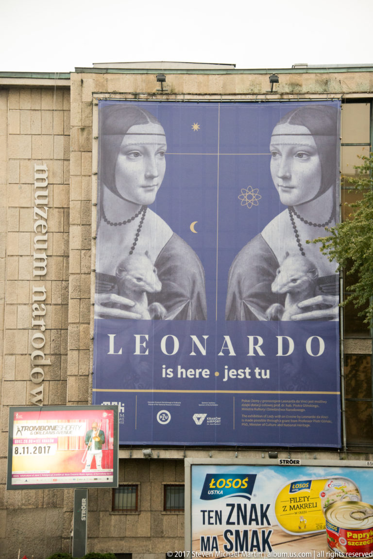 Large National Museum in Kraków banner for Leonardo da Vinci, using mirrored details from Lady with an Ermine and bilingual exhibition text.
