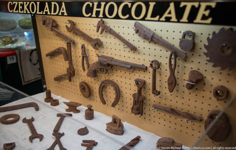 Chocolate replicas of wrenches, pliers, locks, saws, gears, and other tools displayed on pegboard beneath a CHOCOLATE sign.