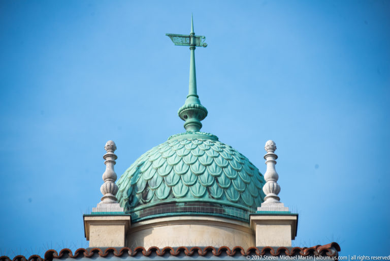 Close view of a small green-scaled dome with finial and weather vane at the Castle Garden Bazaar.