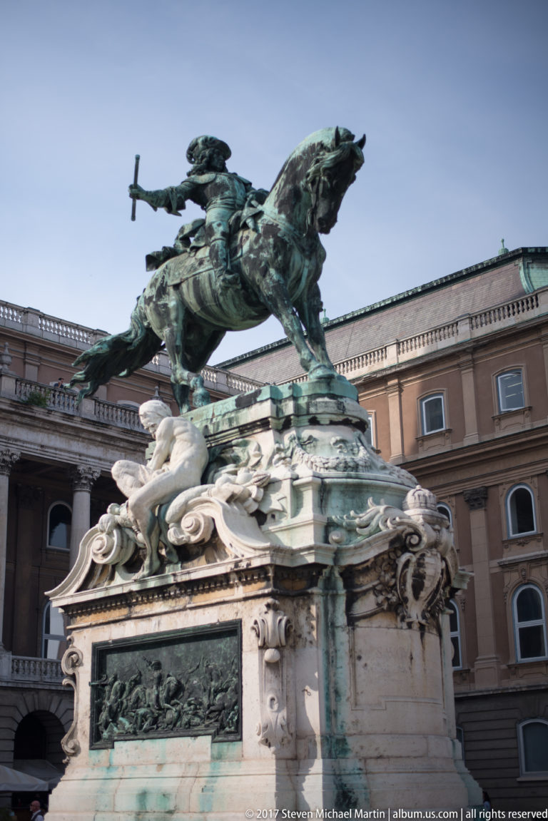 Bronze equestrian statue of Prince Eugene of Savoy on an ornate pedestal before the Royal Palace.
