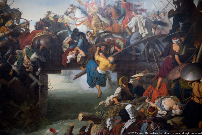 Large museum painting of a chaotic historical battle with cavalry, infantry, fallen soldiers, and smoke.