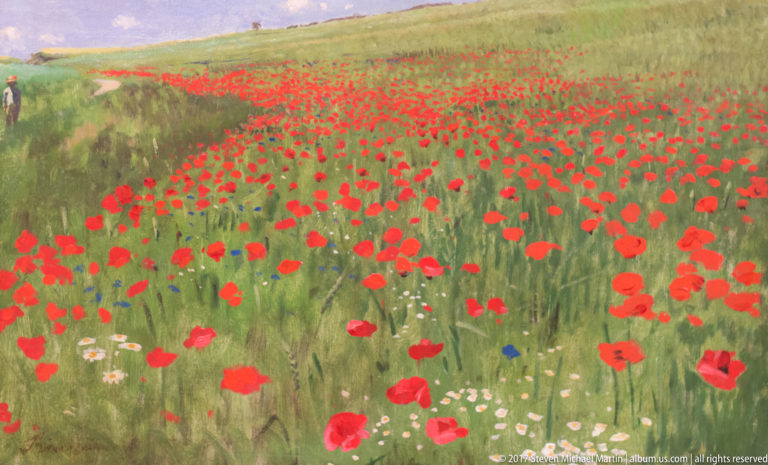 Landscape painting of a green meadow densely scattered with bright red poppies and smaller blue and white flowers.