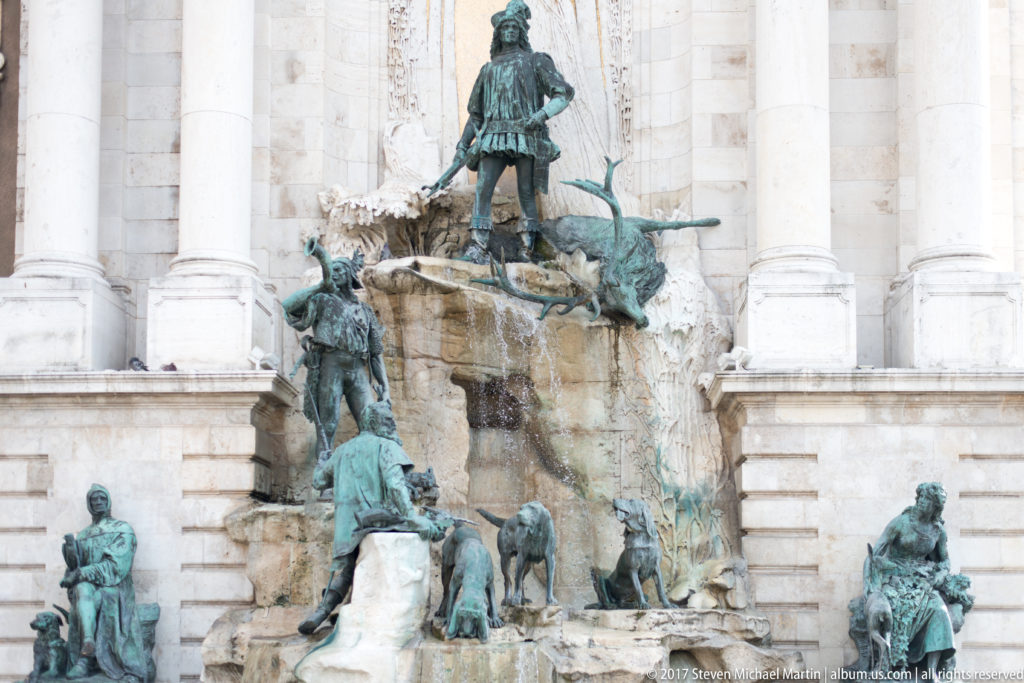 Matthias Fountain with King Matthias, a stag, hunters, hounds, and seated bronze figures on a rocky cascade.