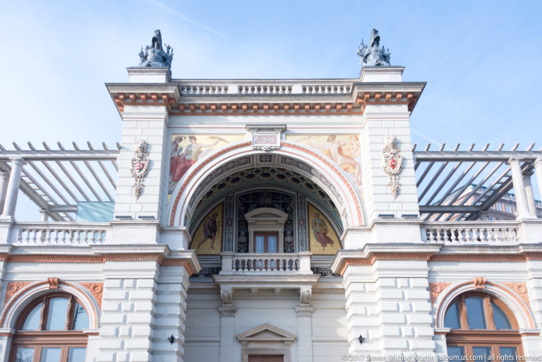 Neo-Renaissance Castle Garden Bazaar pavilion with arches, painted decoration, columns, balustrade, and glazed roof framing.