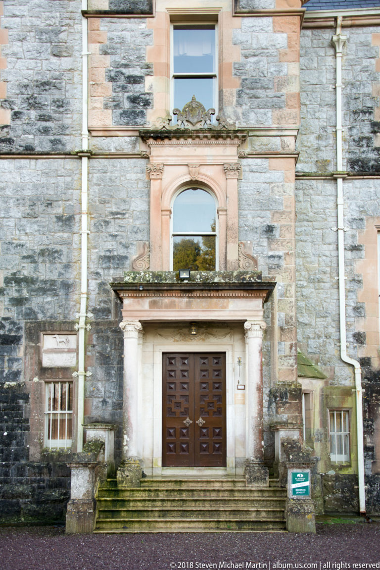 Formal Blarney House entrance with columns, stone surround, paneled wooden door, and broad steps.
