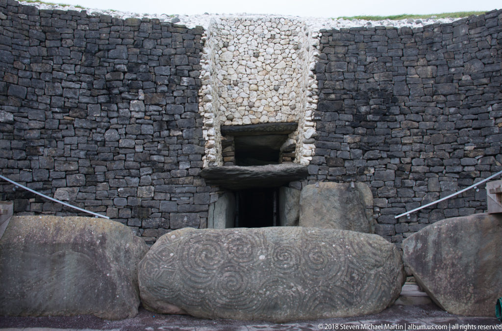 Front view of Newgrange entrance with the decorated entrance stone before the dark passage opening.