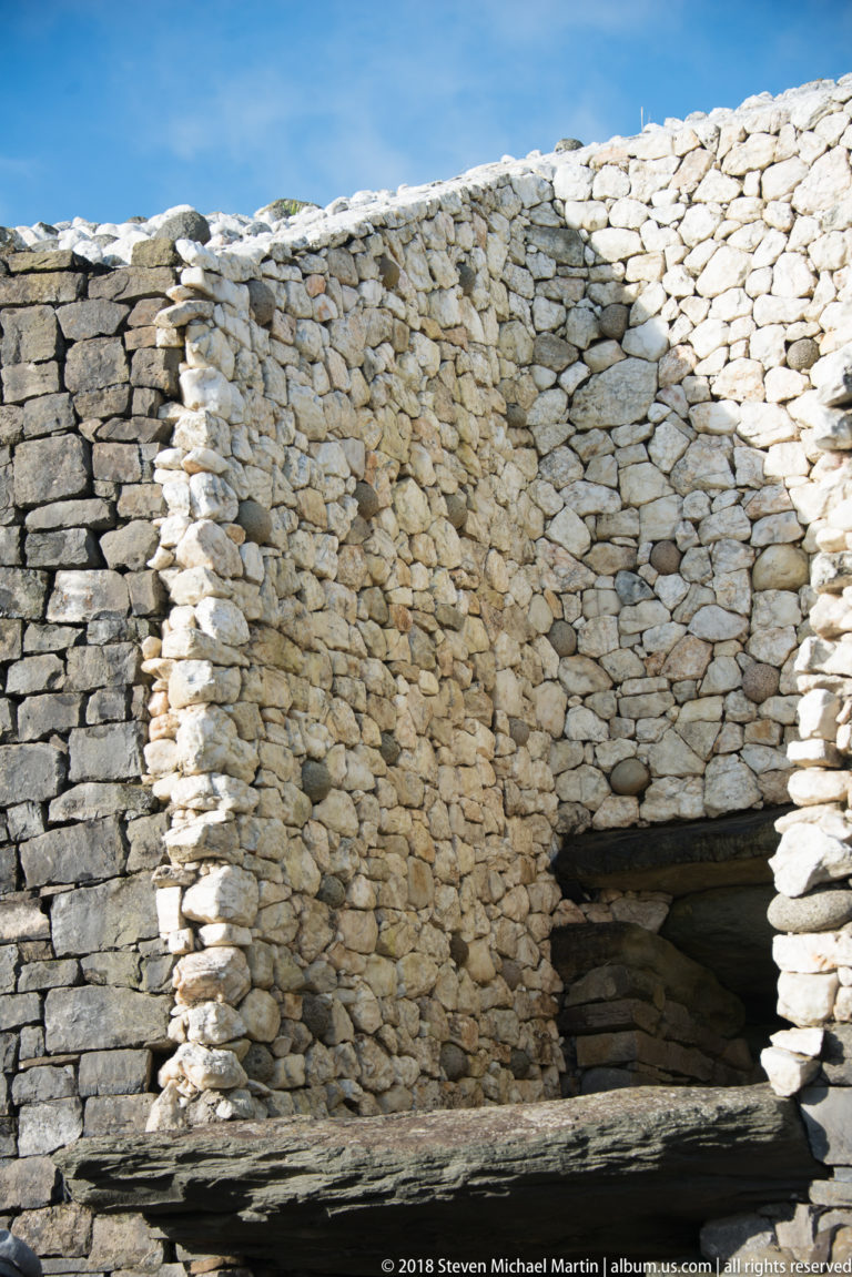 Close view of Newgrange’s recessed passage opening beneath lintels and pale cobble masonry.