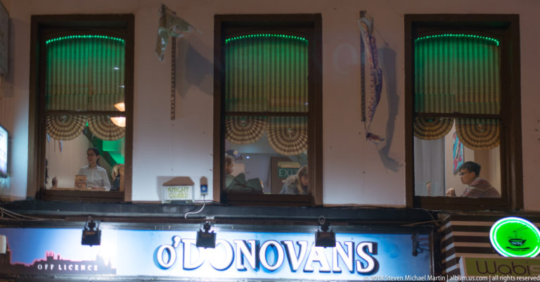 O’Donovans sign below three tall windows with people visible inside and green accent lighting.