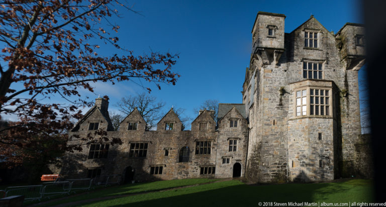 Tall tower block beside a lower gabled castle range around a grass courtyard.