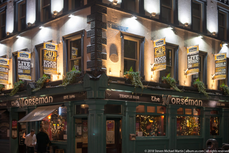 The Norseman pub in Temple Bar at night, with dark green frontage, lit windows, flower boxes, and live-music signs.
