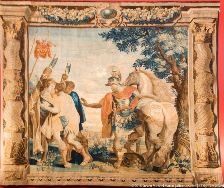 Large tapestry with richly dressed figures, a horse, trees, and ornamental borders hanging in Kilkenny Castle’s Picture Gallery.