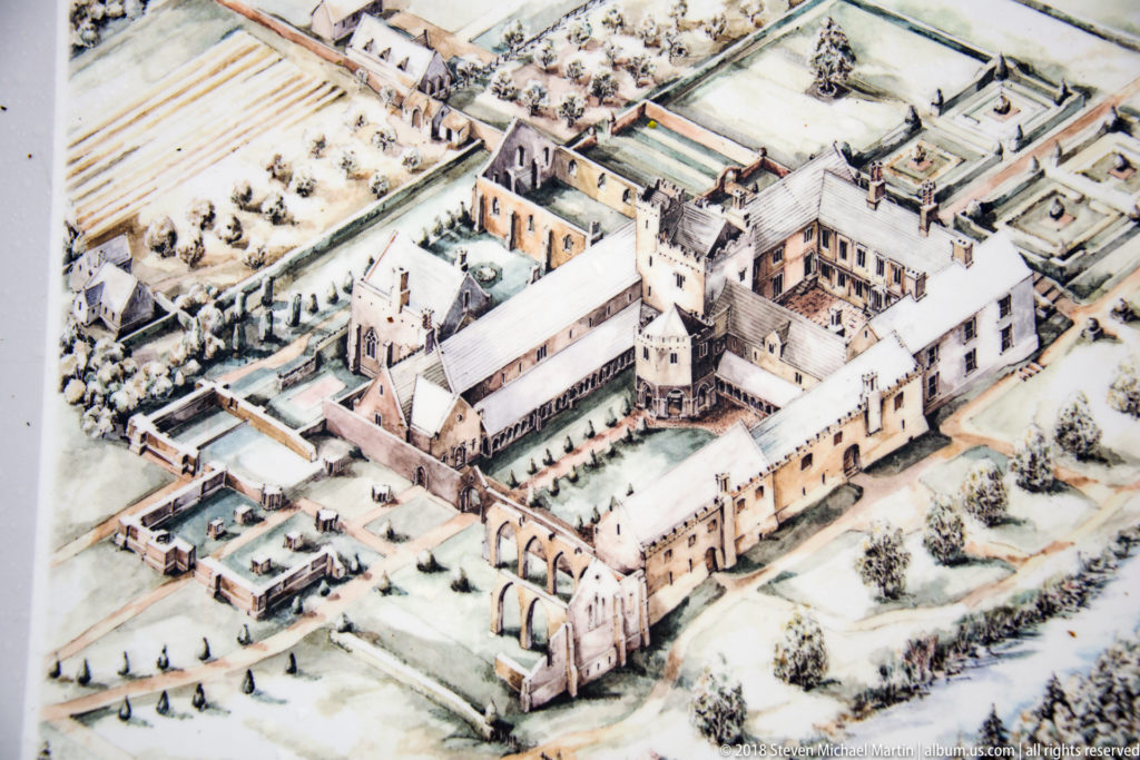 Oblique illustrated reconstruction of a large medieval abbey complex with church, cloister ranges, towers, and surrounding buildings.