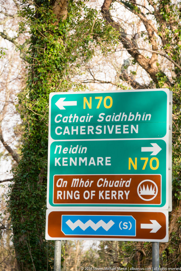 Green and brown roadside sign for the N70, Cahersiveen, Kenmare, and the Ring of Kerry.