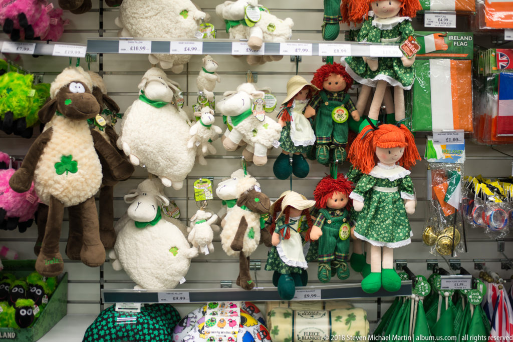 Belfast souvenir display with plush sheep, red-haired dolls in green clothing, shamrocks, and Irish flags.