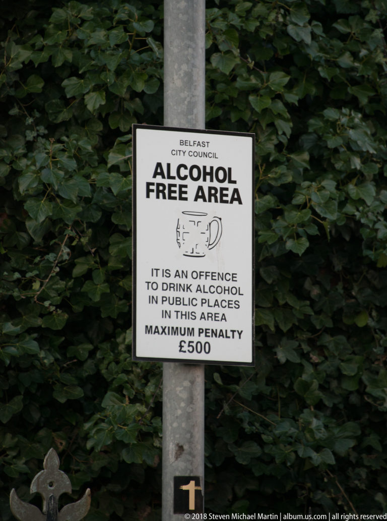 Belfast City Council “ALCOHOL FREE AREA” sign on a metal post, stating a maximum £500 penalty.