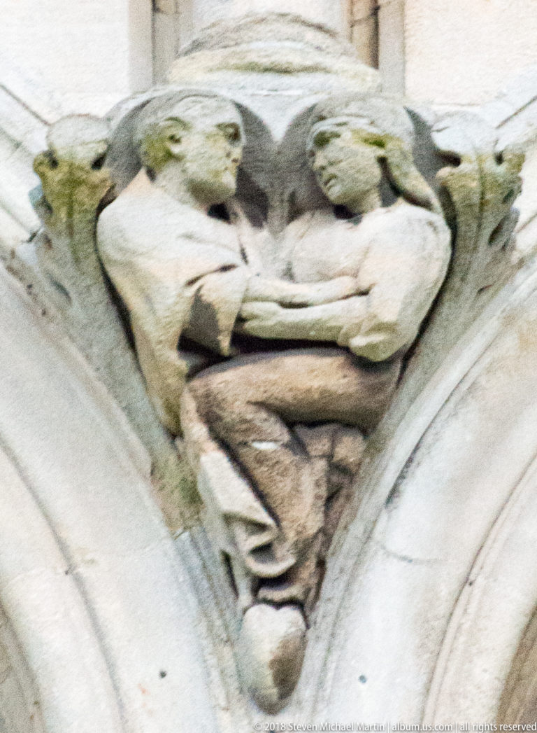 Open-mouthed stone grotesque with a broad face and weathered surface on St Anne's Cathedral.
