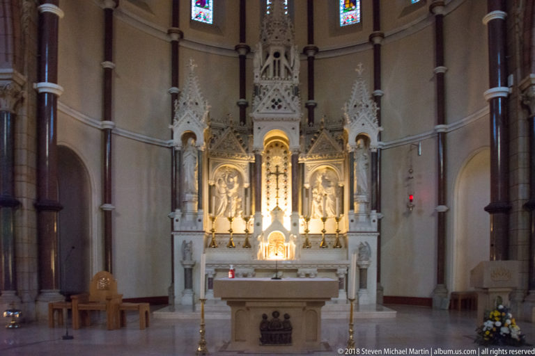Close frontal view of the carved Caen-stone high altar and reredos in St Patrick’s Church, with pinnacles, figures, and central tabernacle.