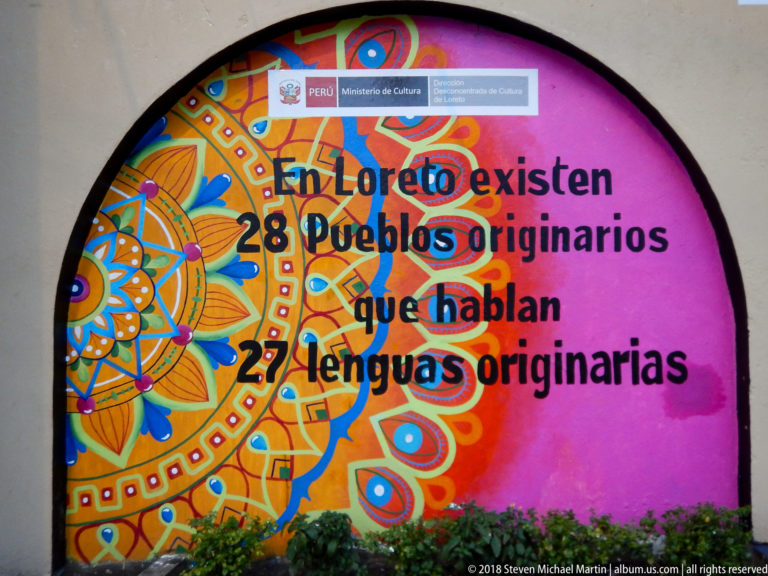 Colorful arched mural stating that Loreto has 28 Indigenous peoples speaking 27 Indigenous languages.