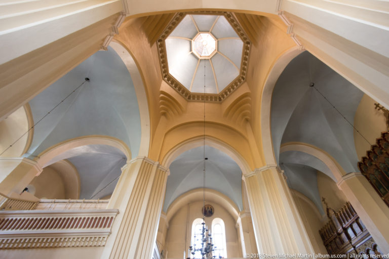 Tall piers, rounded arches, pale vaults, and octagonal lantern inside the Cathedral of the Dormition.