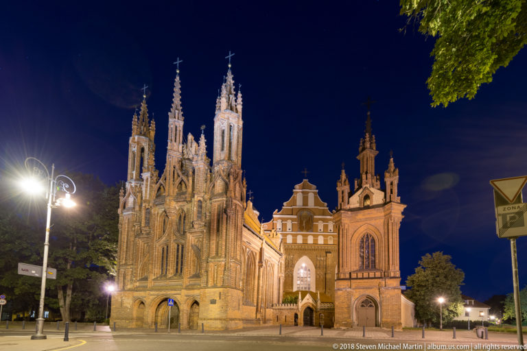 Night view across the street toward the ornate Gothic façade of St. Anne’s Church and the adjoining Bernardine complex.