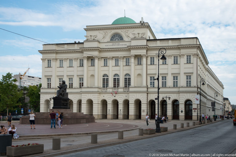 Warsaw University of Technology Main Building with central portico, sculpted pediment, and green dome.