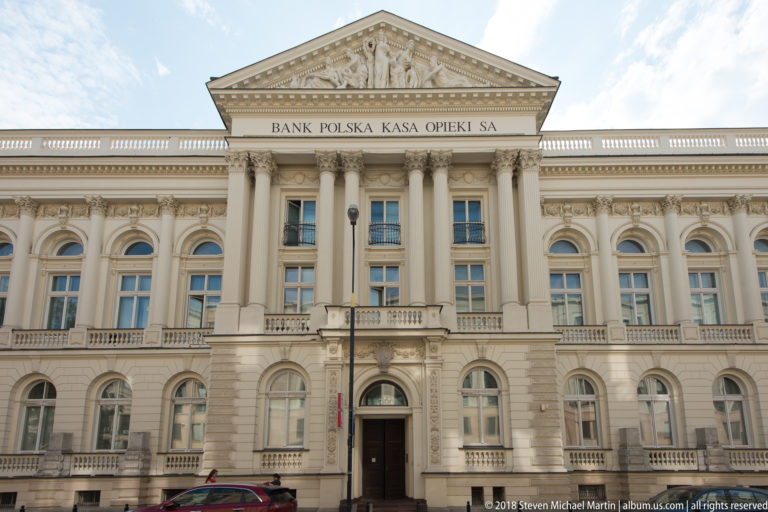 Historic Bank Polska Kasa Opieki SA facade with tall classical columns, arched windows, and a pediment.