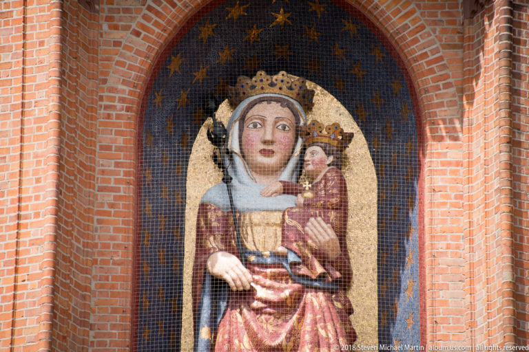 Close view of the crowned Virgin holding the crowned Christ Child against a dark blue mosaic field scattered with gold stars.