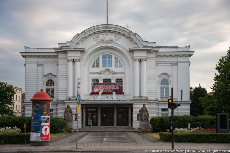 White historicist façade of the Wilam Horzyca Theatre with monumental arched center and entrance steps.