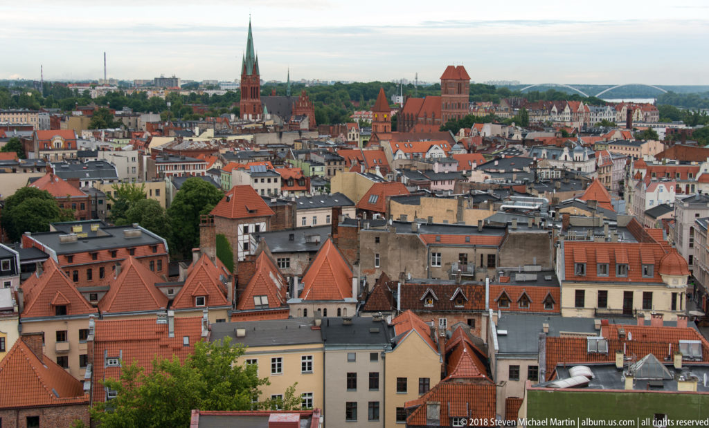 Elevated panorama of Toruń Old Town with red roofs, church spires and medieval towers.