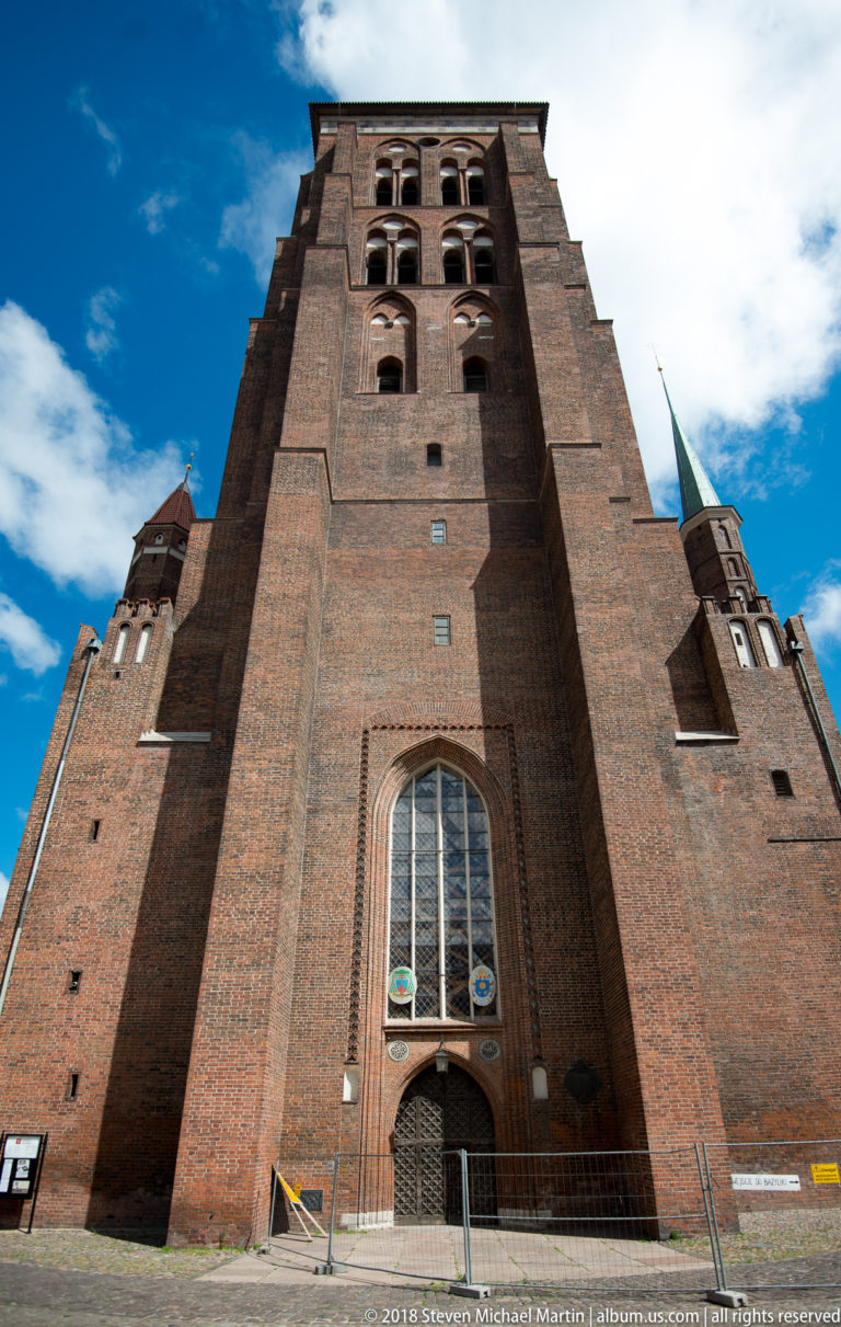 Low-angle view up the massive brick western tower of St. Mary’s Basilica in Gdańsk.