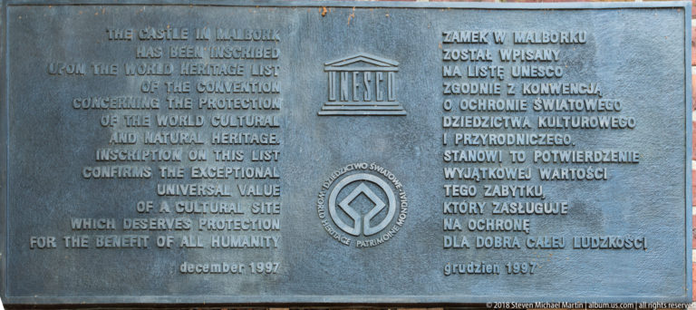 Metal UNESCO World Heritage plaque with English and Polish inscriptions, UNESCO emblems, and the date December 1997.