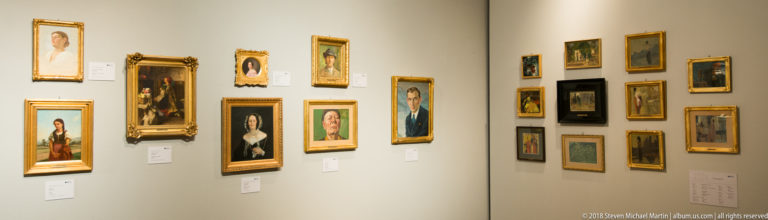 Corner gallery wall densely hung with small framed portraits and paintings in gilded and dark frames, each with museum labels.