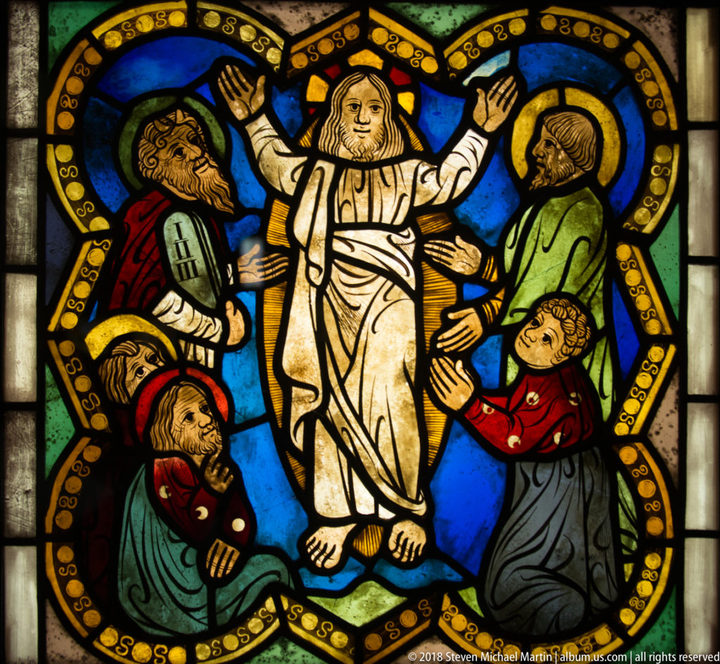 Transfiguration of Christ with Moses and Elijah flanking him and apostles reacting below.