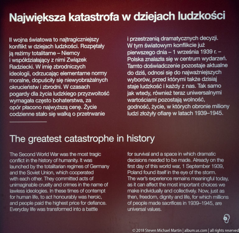 Bilingual Polish-English museum panel headed The greatest catastrophe in history, with several paragraphs of white text on dark red.