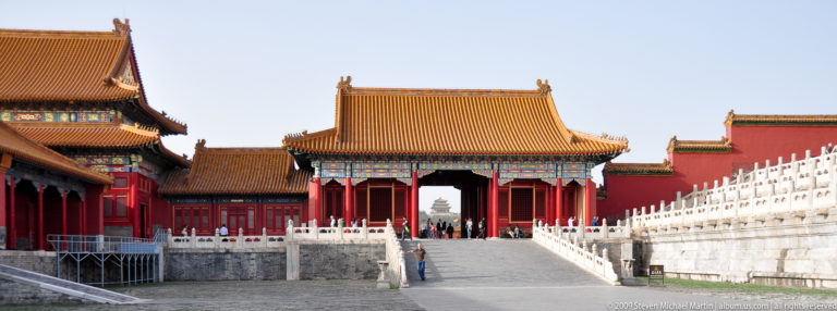 Symmetrical yellow-roofed gate pavilion on the central axis of the Forbidden City, approached by a broad ramp with stone balustrades.