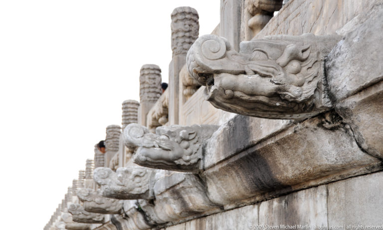 Carved stone dragon-head spouts projecting from the edge of a terrace in the Forbidden City.