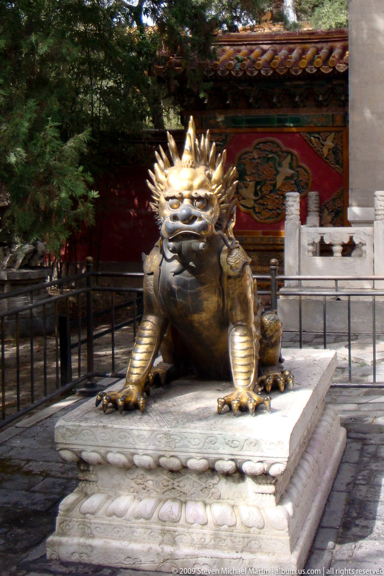 Bronze horned guardian beast with a scaled body seated upright on a stone base in the Forbidden City.
