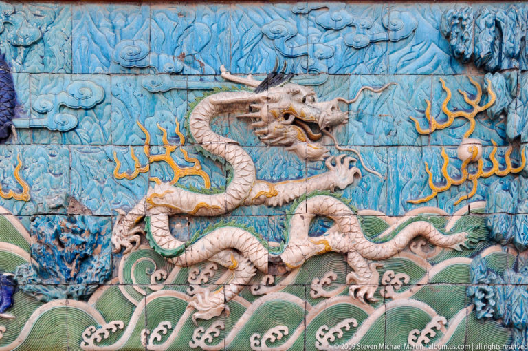 Glazed ceramic panel showing a five-clawed white dragon above green waves on the Nine-Dragon Screen in the Forbidden City.