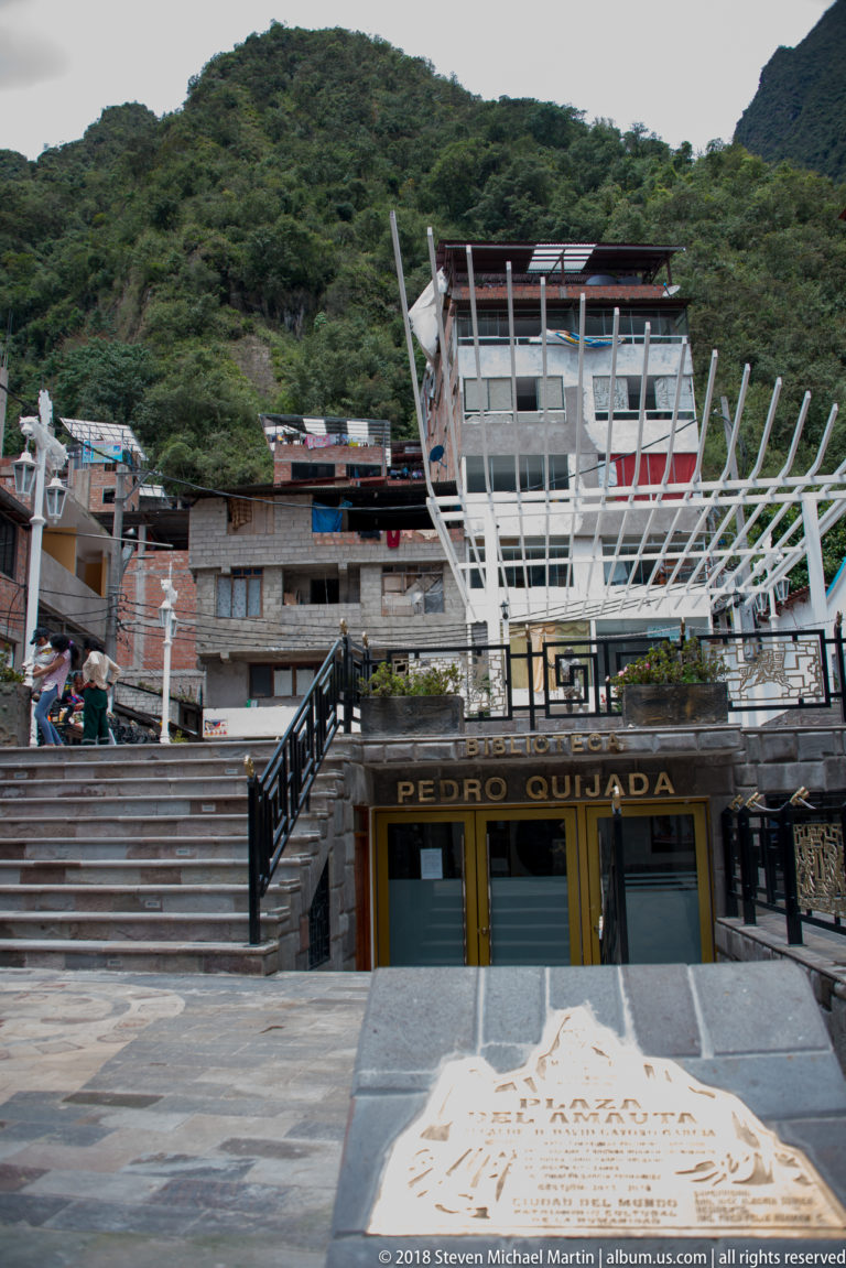 Stone-paved steps and railings lead to a modern white canopy above a building labeled “Pedro Quijada.”