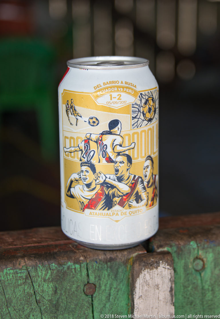 Small beverage can with football illustrations, a soccer ball, and Spanish Russia 2018 promotional text on a green wooden ledge.
