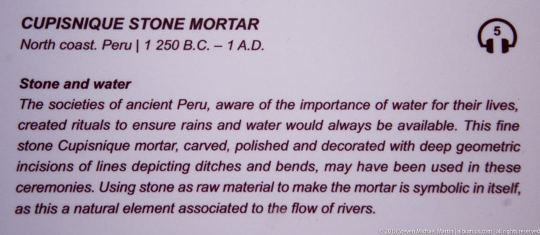 Interpretive label for a Cupisnique stone mortar, describing polished stone, deep geometric incisions, and ceremonial associations with water.