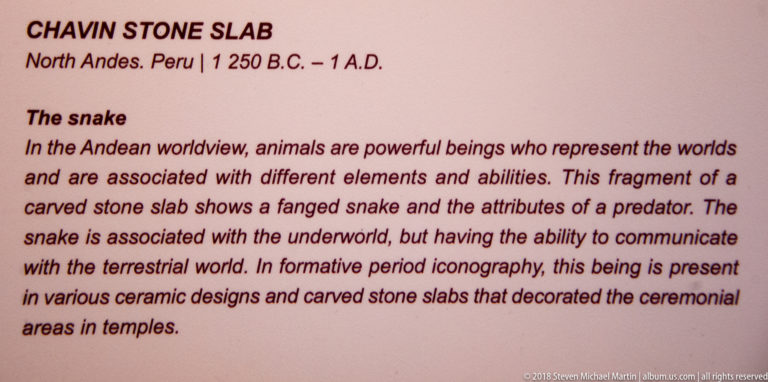 Interpretive panel about a carved stone slab with a fanged snake, linking serpent imagery to the underworld and ceremonial contexts.