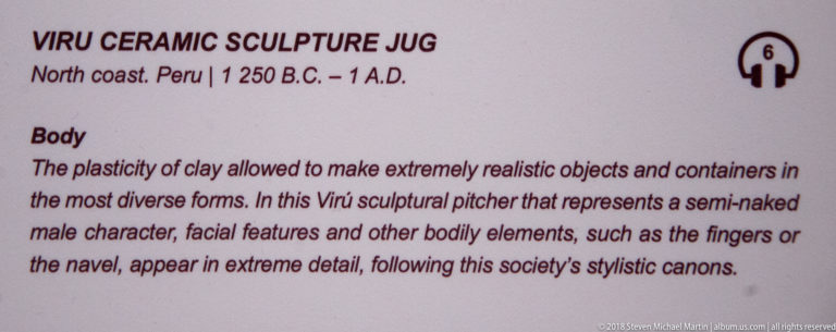 Interpretive panel for a Virú sculpture jug, describing a modeled male figure with detailed face, fingers, and navel.