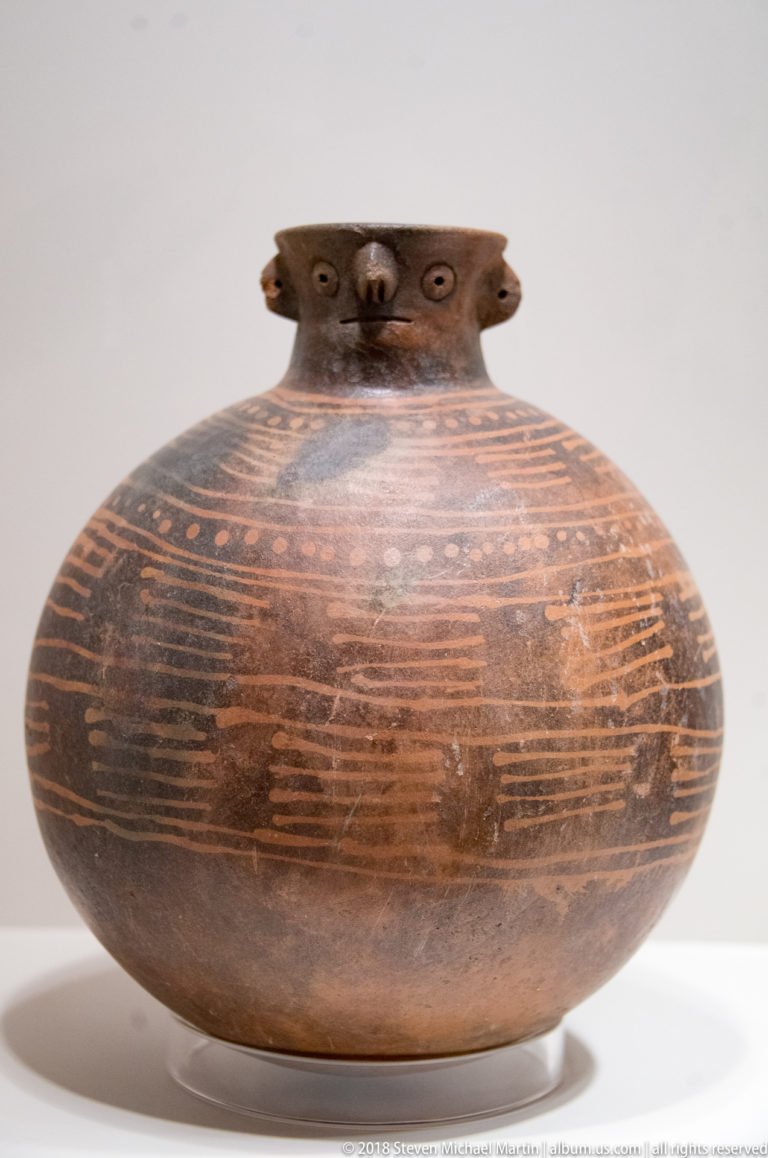 Rounded Virú ceramic vessel with painted linear motifs across its broad body.