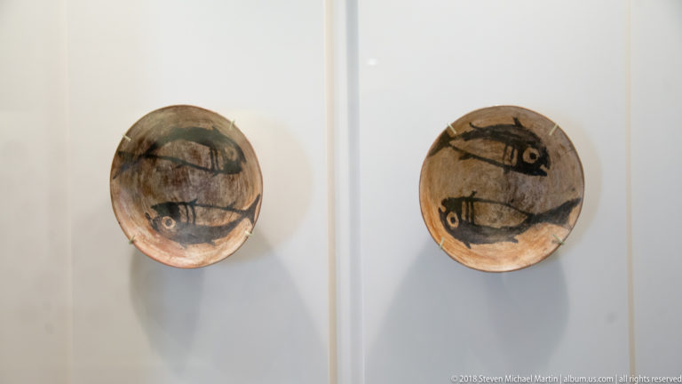 Nasca two small weathered ceramic bowls mounted side by side, each with a dark fish-like figure painted inside.